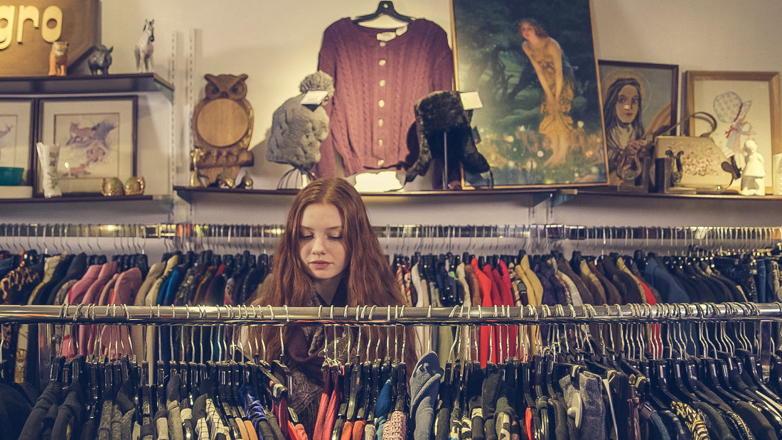 Shopper browsing a rack of vintage shirts in a thrift store